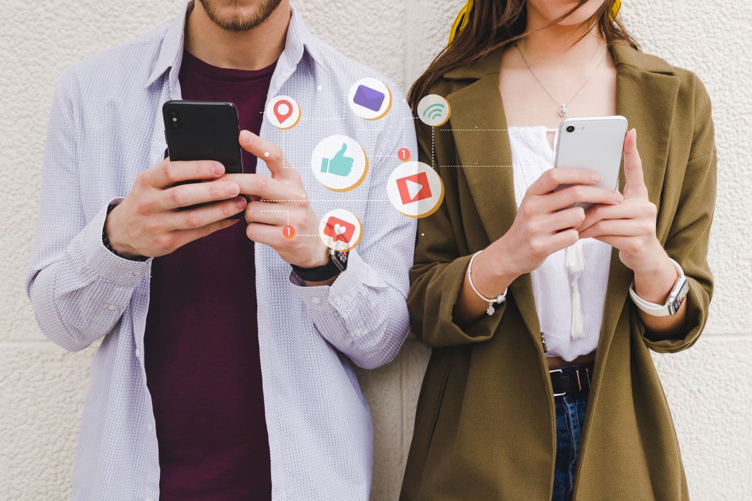 Twee mensen met smartphones waartussen pictogrammen van sociale media voor likes, video, locatie en berichten zweven